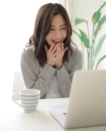 笑顔でパソコンを見る女性